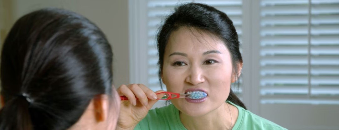 woman with dental implants brushing teeth